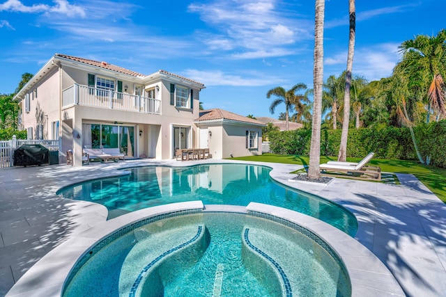 view of swimming pool with an in ground hot tub, grilling area, and a patio