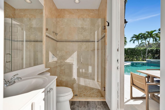 bathroom featuring an enclosed shower, vanity, hardwood / wood-style flooring, and toilet