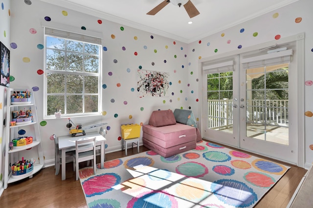 playroom with crown molding, dark wood-type flooring, and a healthy amount of sunlight