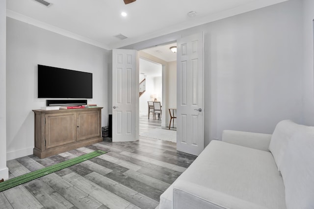 bedroom featuring ornamental molding and light hardwood / wood-style floors