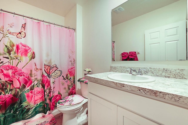 bathroom featuring curtained shower, toilet, and vanity