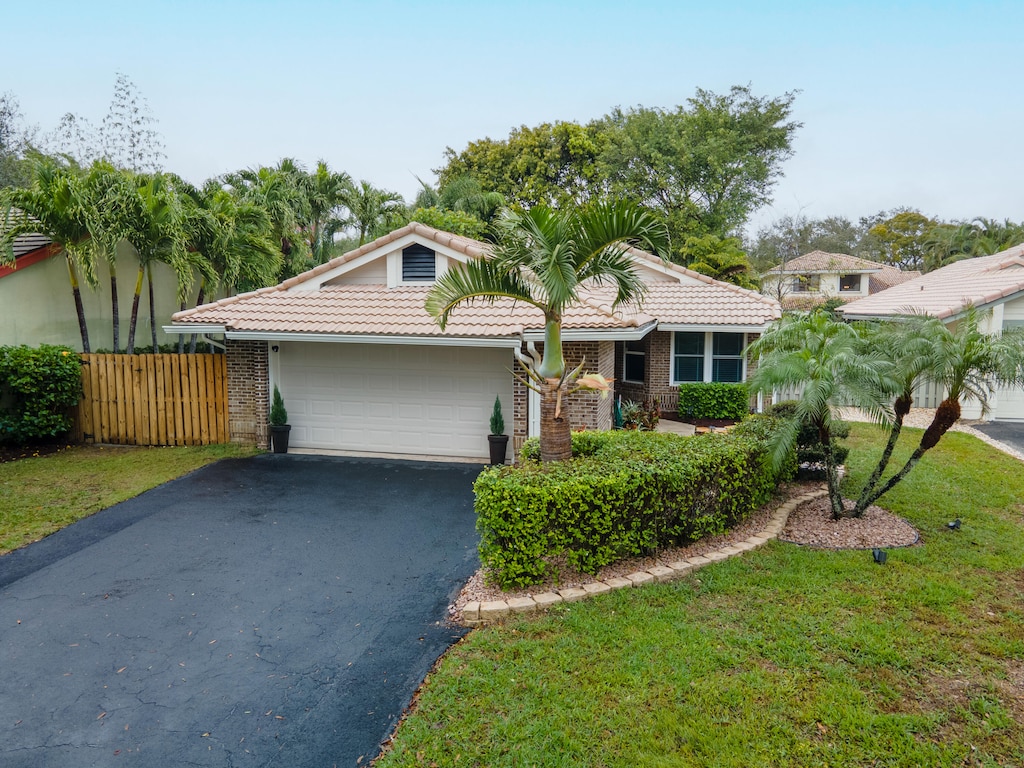 view of front of house featuring a garage and a front lawn