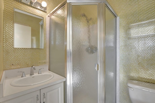 bathroom with vanity, a shower with shower door, and toilet
