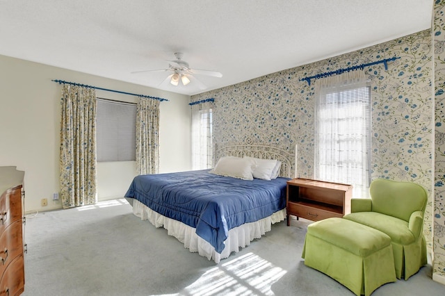 bedroom with multiple windows, a textured ceiling, ceiling fan, and carpet
