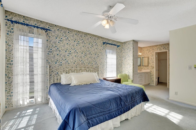 carpeted bedroom with a spacious closet, a textured ceiling, ceiling fan, and a closet