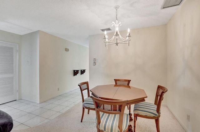 tiled dining space featuring a notable chandelier and a textured ceiling
