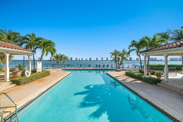 view of swimming pool with a water view and a patio