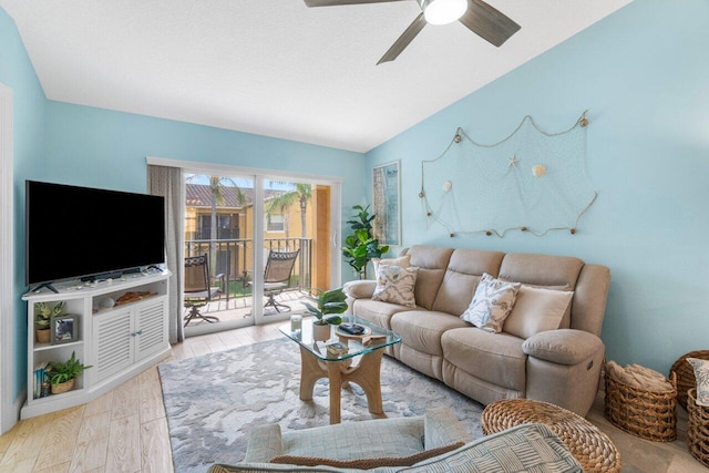 living room featuring ceiling fan, light hardwood / wood-style flooring, and vaulted ceiling