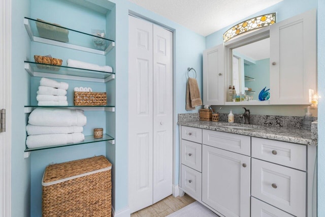 bathroom featuring a textured ceiling and vanity