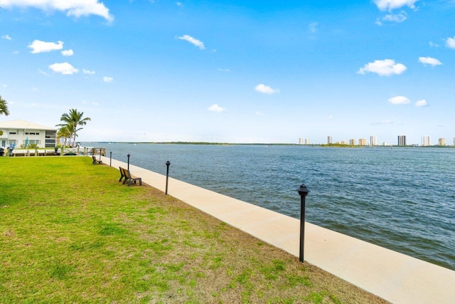 view of dock featuring a water view and a yard