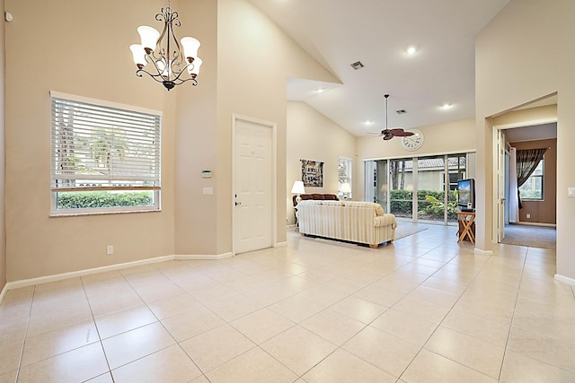 foyer entrance featuring light tile patterned floors, ceiling fan with notable chandelier, and high vaulted ceiling