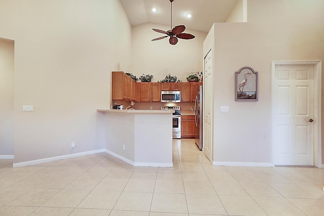 kitchen featuring light tile patterned flooring, high vaulted ceiling, ceiling fan, kitchen peninsula, and stainless steel appliances