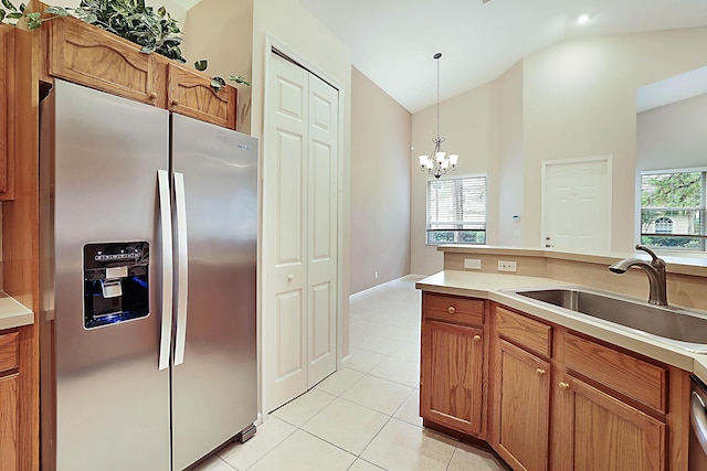 kitchen featuring lofted ceiling, sink, hanging light fixtures, light tile patterned floors, and appliances with stainless steel finishes