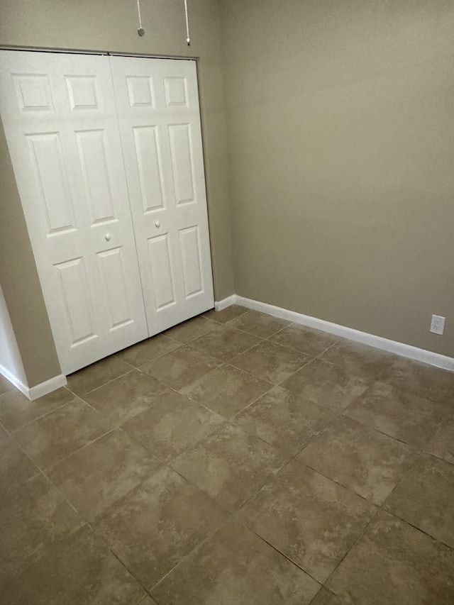 unfurnished bedroom featuring a closet and baseboards