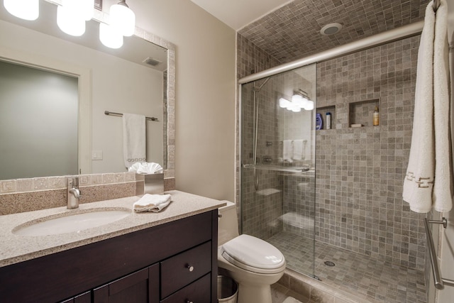 bathroom with vanity, toilet, and a shower with shower door