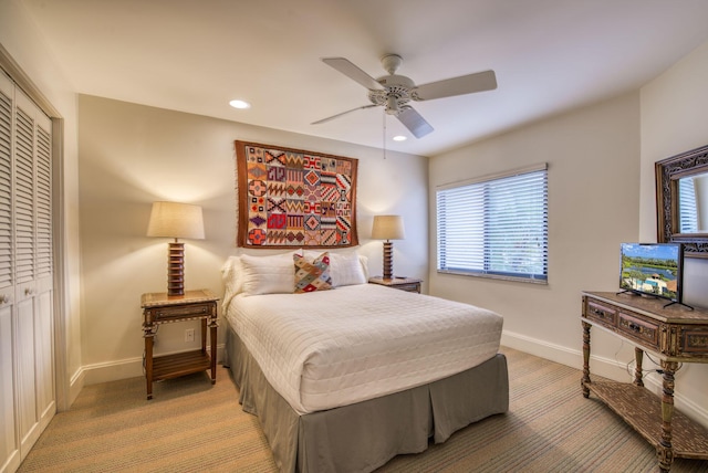 bedroom featuring light carpet, ceiling fan, and a closet