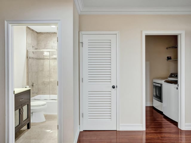 full bathroom with shower / bath combination with glass door, vanity, independent washer and dryer, toilet, and crown molding