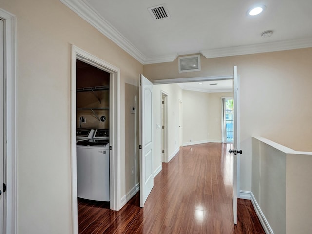 hall with ornamental molding, dark hardwood / wood-style floors, and washer and dryer