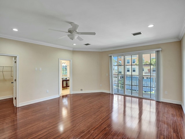 empty room featuring dark hardwood / wood-style flooring, crown molding, and ceiling fan