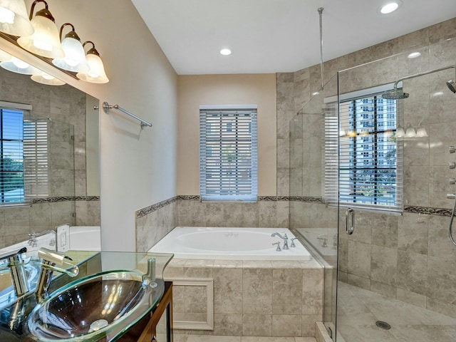 bathroom featuring plus walk in shower, sink, and a healthy amount of sunlight