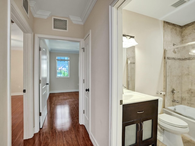 interior space with toilet, shower / bath combination with glass door, ornamental molding, vanity, and hardwood / wood-style flooring