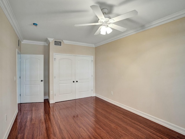 unfurnished bedroom with dark wood-type flooring, ceiling fan, ornamental molding, and a closet