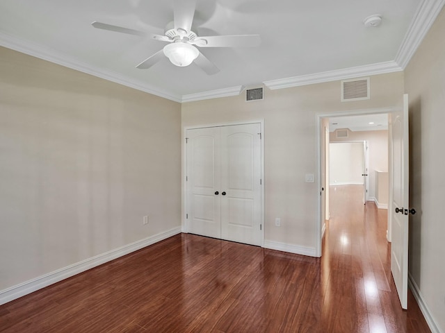 unfurnished bedroom featuring hardwood / wood-style floors, crown molding, a closet, and ceiling fan