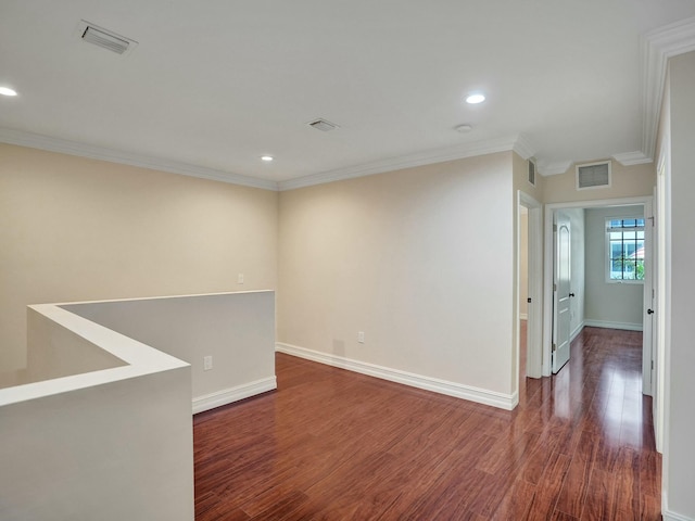 empty room with dark hardwood / wood-style flooring and crown molding