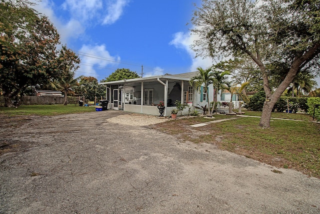 view of front of house with a front lawn and a sunroom