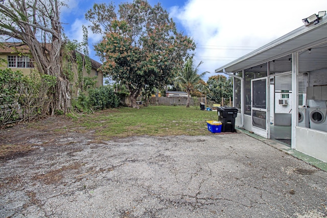 view of yard featuring a sunroom and washer and dryer