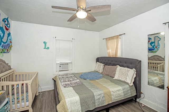 bedroom featuring cooling unit, ceiling fan, and hardwood / wood-style floors