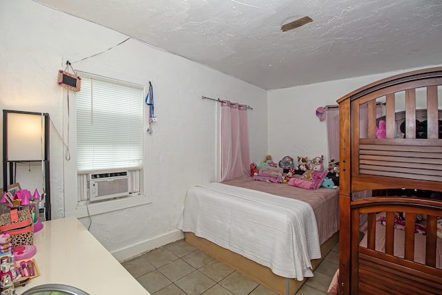 bedroom with cooling unit, a textured ceiling, and light tile patterned floors