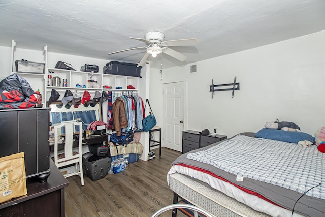 bedroom with dark hardwood / wood-style flooring, a textured ceiling, and ceiling fan