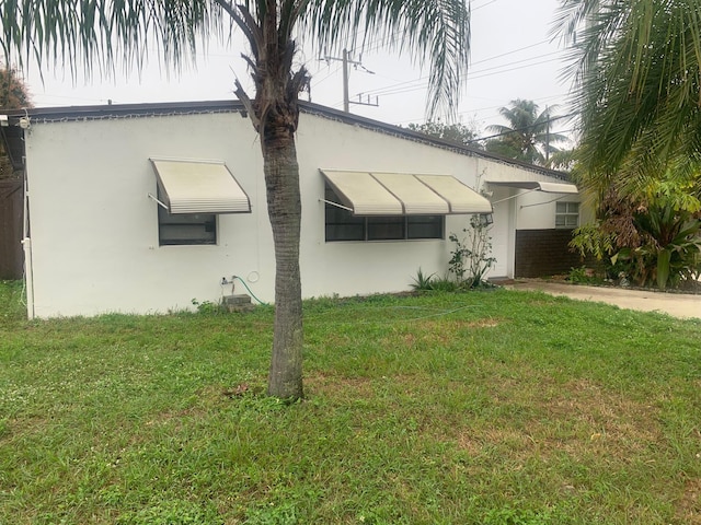 view of front of property with a front yard and stucco siding