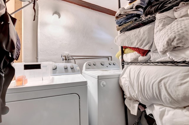 laundry room featuring independent washer and dryer, a textured wall, and laundry area