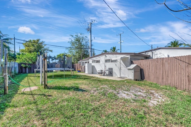 view of yard featuring a trampoline and a fenced backyard