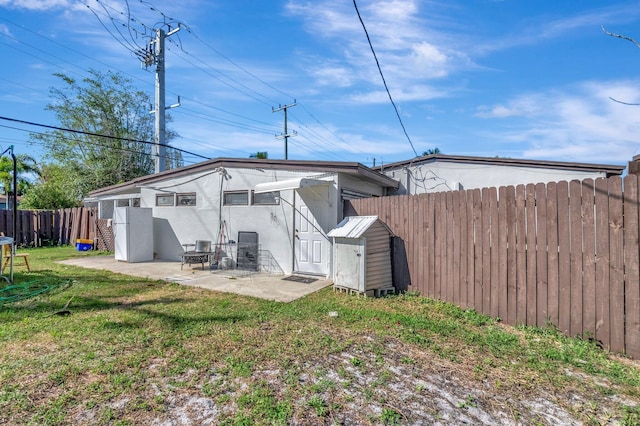 back of property with stucco siding, a fenced backyard, a yard, and a patio area