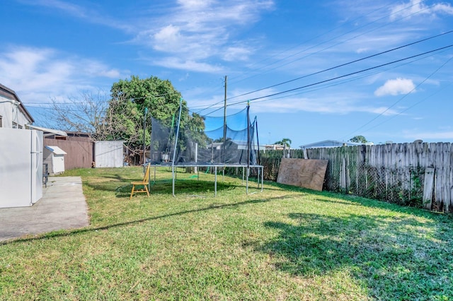 view of yard with a trampoline and a fenced backyard