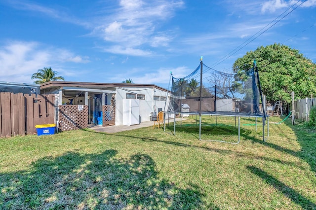 view of yard with fence and a trampoline