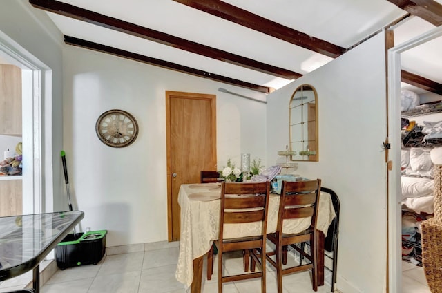dining room with light tile patterned flooring and beamed ceiling