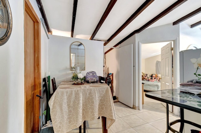 dining area with lofted ceiling with beams and light tile patterned floors