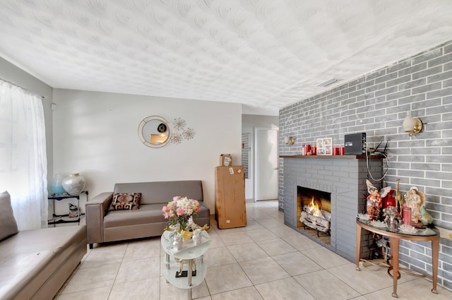 tiled living area featuring a textured ceiling, a fireplace, and visible vents