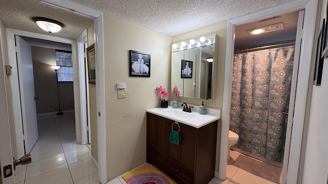 bathroom featuring toilet, a textured ceiling, walk in shower, tile patterned floors, and vanity