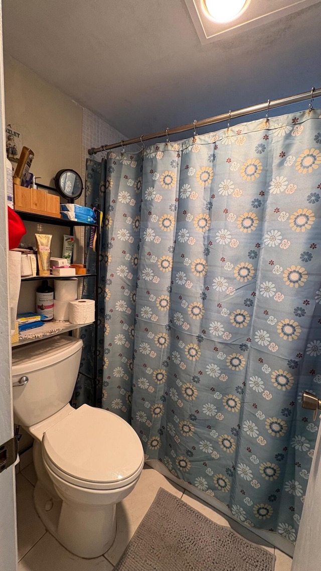 bathroom featuring toilet and tile patterned flooring