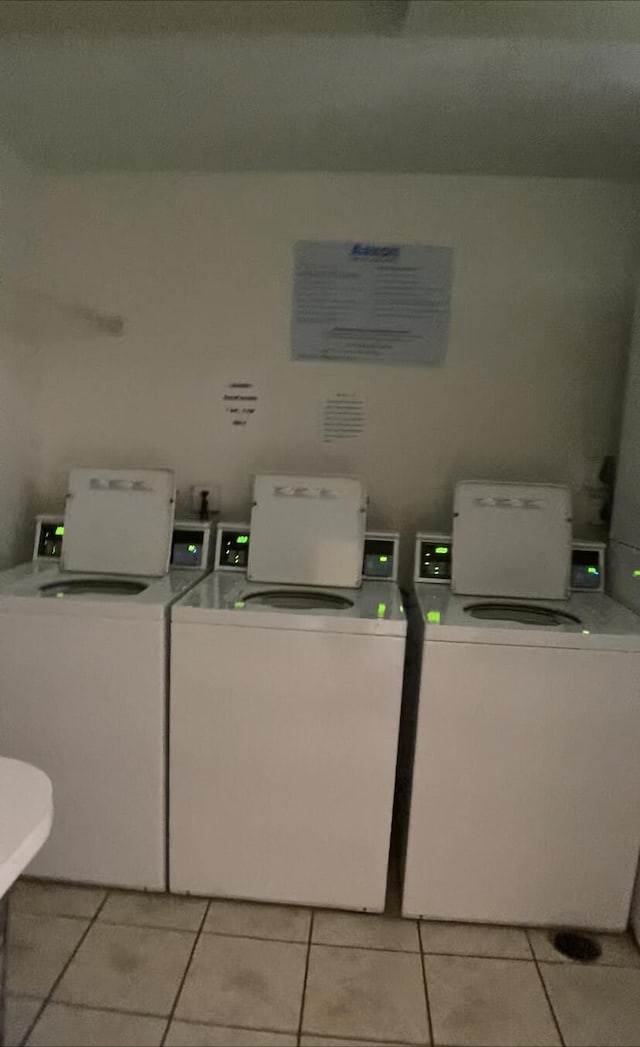 clothes washing area featuring washer and clothes dryer and light tile patterned floors