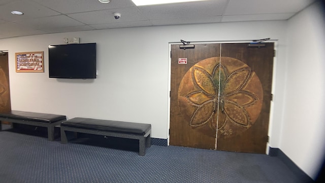 interior space featuring a paneled ceiling and carpet