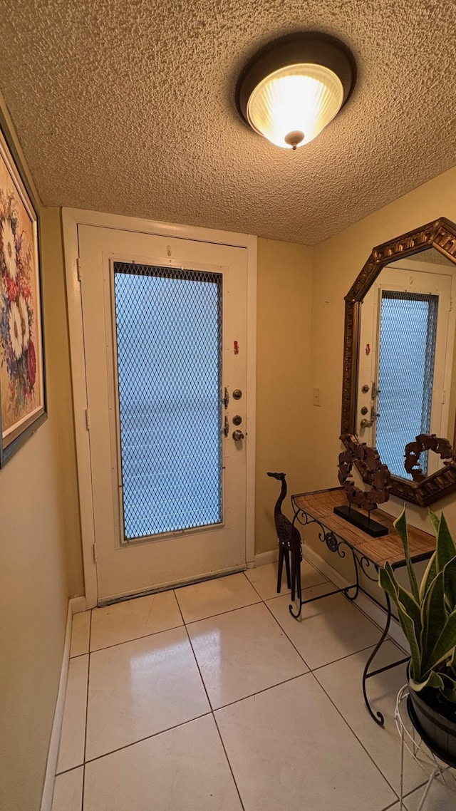 doorway to outside featuring a textured ceiling and light tile patterned flooring