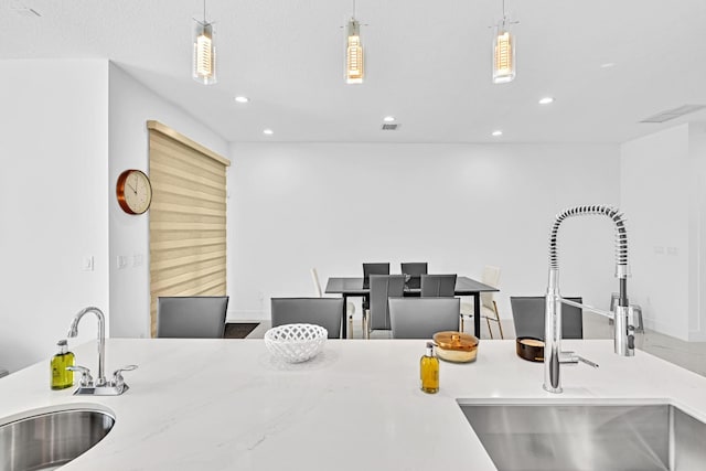 kitchen with sink, hanging light fixtures, and a textured ceiling