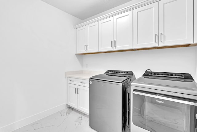 laundry area with cabinets and washing machine and clothes dryer