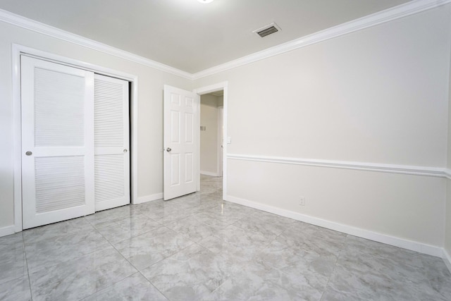 unfurnished bedroom with a closet and crown molding